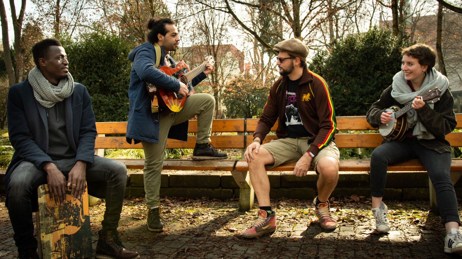 Vier Personen beim Musizieren im Park